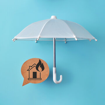 White umbrella protecting a house symbol, creating a minimalist visual concept for home insurance, property protection, and financial security.