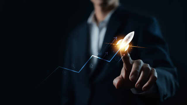 Business growth concept with a professional touching a glowing rocket icon on an upward trend chart, symbolizing startup success, innovation, investment, strategy, and accelerated growth.