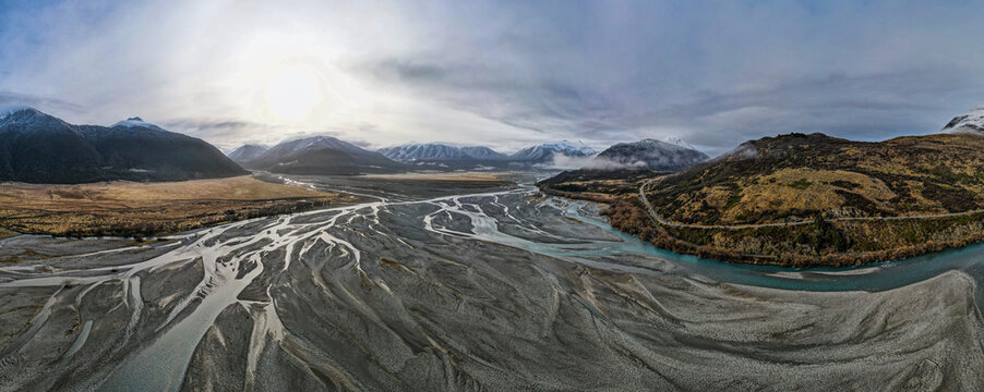 Aerial view of the braided river system flowing through the mountainous landscape of the Canterbury Region, New Zealand.