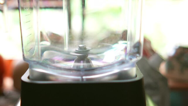 4K Close up of empty electric blender with sharp stainless steel blades inside a clear jar, ready for making smooth smoothies and fresh fruit juice concept.