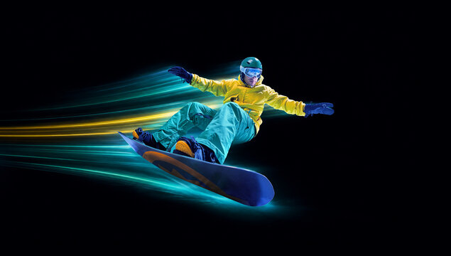 Snowboarder performs aerial trick through turquoise energy trails. Concept of winter sport freedom, aerial skill, extreme action and snowboard advertising.