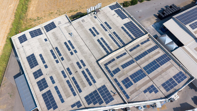 Aerial view of chemical manufacturing buildings featuring extensive rooftop solar panels for renewable energy integration in an industrial facility in Milan, Lombardy, Italy.