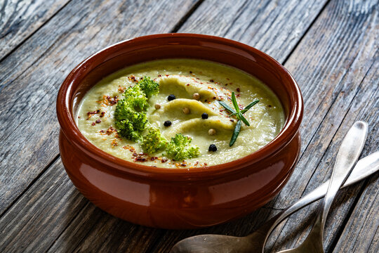 Cream of broccoli soup on wooden table
