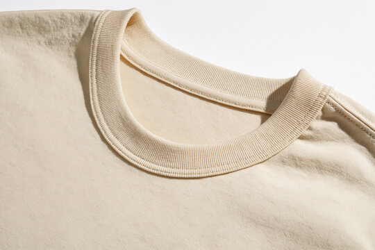 A close-up view of the beige cotton t-shirt collar neckline shows detailed stitching texture. This garment detail mockup is ideal for apparel and fashion brand presentations.