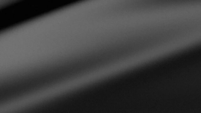 Black abstract background with grainy texture and soft flowing light