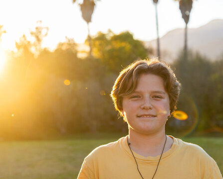 portrait of 13 year old boy smiling at sunset
