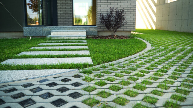 Modern house entrance with concrete stepping stones pathway and ecological grass paver driveway for green parking design