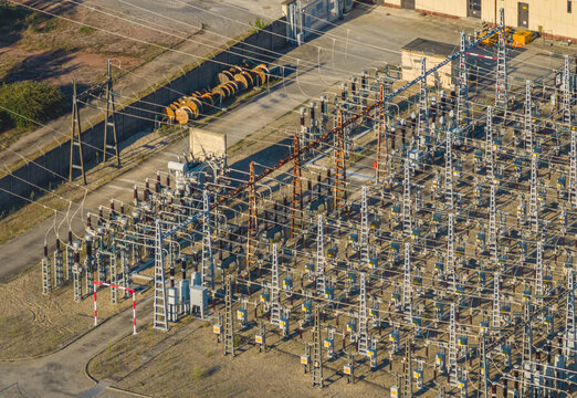 Aerial view of a high voltage electrical substation with power distribution equipment, transformers, insulators, and transmission lines in Saulce-sur-Rhone, Auvergne-Rhone-Alpes, France.