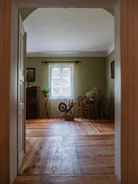 Vintage Rustic Interior With Wooden Floor, Lace Window, Spinning Wheel and Small Dining Table