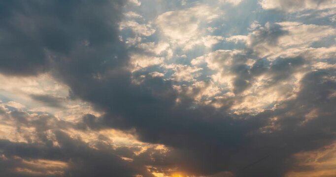 Dramatic storm clouds with sun rays at sunset