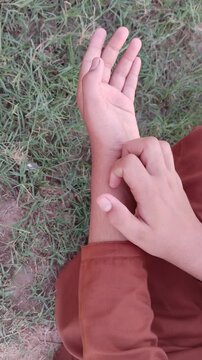 Woman scratching itchy arm skin. Close up of hand scratching allergic rash reaction or mosquito bite outdoors