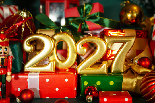 Golden numbers 2027, Christmas balls,  nutcracker and elegant red and green gift boxes.