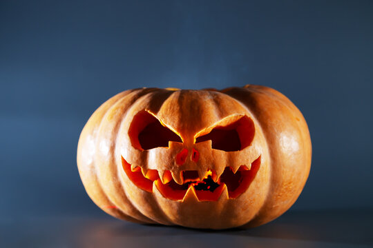 Halloween pumpkin with a scary face on a gray background.