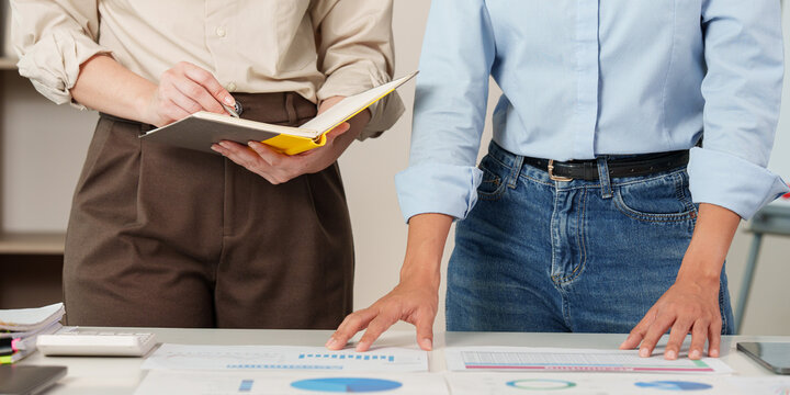 Two business professionals analyzing financial documents during team strategy meeting