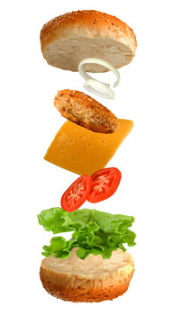 Stacking of sandwich ingredients with a top bun, onion, chicken patty, cheese, tomato, lettuce, and bottom bun isolated on transparent background, PNG file