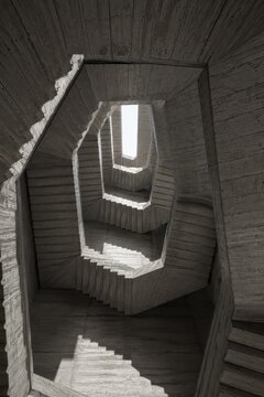 Brutalist concrete stairwell spiral seen from below
