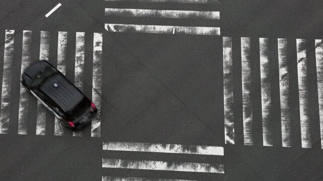 Tokyo Scene  :  Bird's-Eye View of Numerous Vehicles Passing Through a Large Intersection as the Worn White Stripes of the Zebra Crossing Bear Witness to the Heavy Traffic  |  Tokyo, Japan