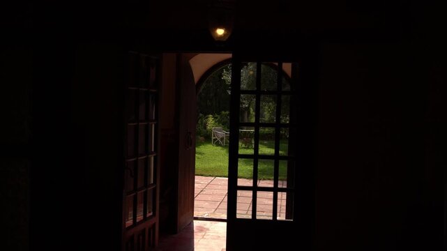 A handheld shot shifts slightly from side to side showing the entrance of a stone farmhouse