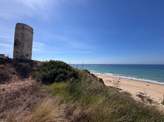 Torre del Puerco - historical watchtower at the Atlantic Ocean with view to the beautiful beach Playa del Puerco near Novo Sancti Petri, Roche, Cadiz, Costa de la Luz, Andalusia, Spain © keBu.Medien