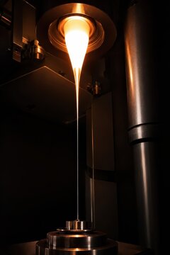 Optical fibre drawn from a glowing preform in a draw tower
