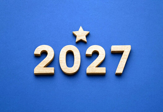 Golden wooden numbers and star for the new year celebration on blue background