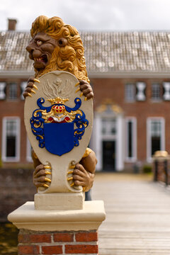 Close up of a beautiful lion statue with removed family weapon at the drawbridge of noble house and estate Menkemaborg, Uithuizen, Groningen, the Netherlands.