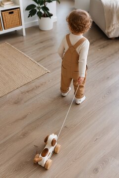 Toddler joyfully pulling a toy dog across a cozy living room