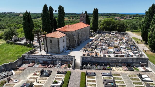 Aerial view of the historic church and cemetery surrounded by cypress trees and lush greenery in Danci, Istarska zupanija, Croatia.