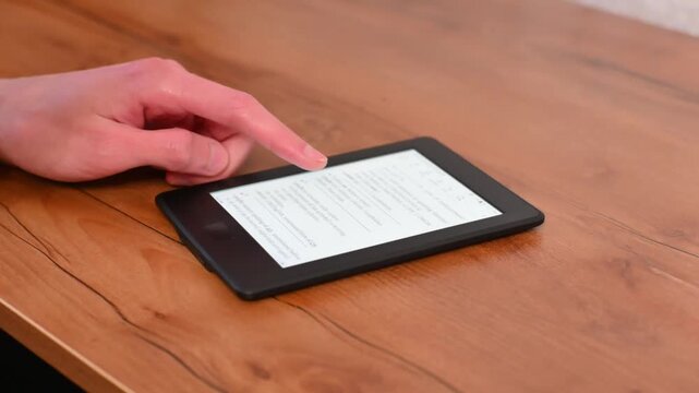 Self education with electronic reader device in hand at home table