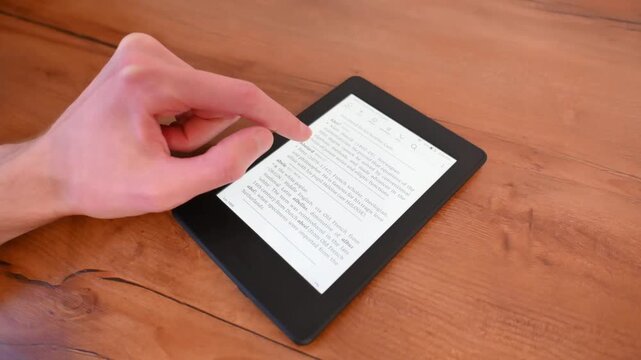 Quiet focus while holding digital reader on natural wooden table