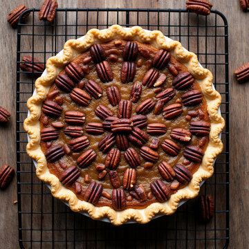 Top view of freshly baked homemade lattice apple pie on wooden table with napkin