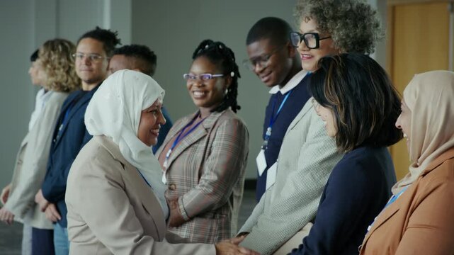 Woman wearing a hijab engages in handshakes and networking with fellow professionals. This collaborative business event fosters connections and builds partnerships among attendees.