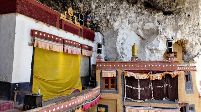Zanskar, India : Tilt down footage of building exterior of Phuktal gompa, cliffside monastery built in natural cave of Zanskar in Ladakh, India surrounded by arid mountain