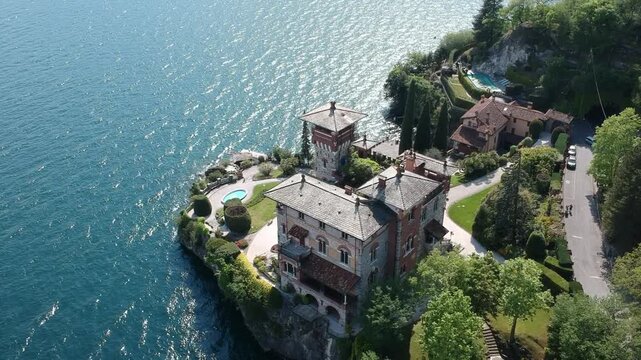 Drone aerial above Villa La Gaeta on Lake Como, Italy, showing gardens, pool and rocky shoreline