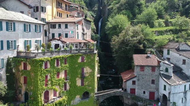 Drone aerial of Nesso, Lake Como, Italy, featuring ivy covered homes and Ponte della Civera