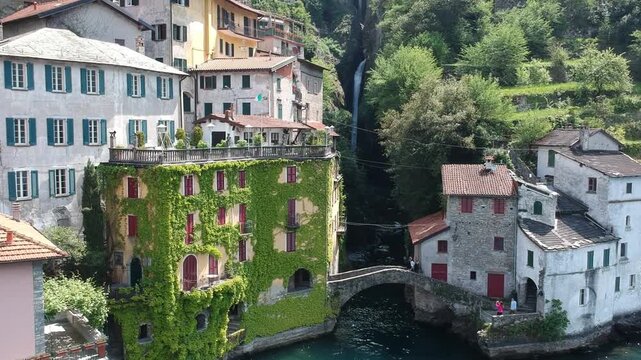Historic Nesso on Lake Como, Italy, captured by drone with waterfall, stone bridge and houses