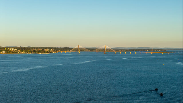 Aerial view of the International Bridge San Roque Gonzalez of Santa Cruz spanning the Parana River with boats navigating the water near the city of Posadas, Misiones Province, Argentina.