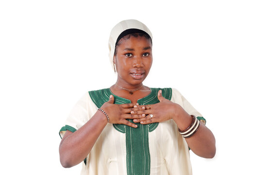 Young African woman with both hands clasped on her chest, a gesture of gratitude, white background