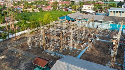 Fototapeta premium Aerial view of a power station distributing electricity to a residential area during the day
