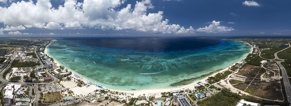 Aerial view of Seven Mile Beach with turquoise water, white sand, and coastal development in Grand Cayman, Cayman Islands.