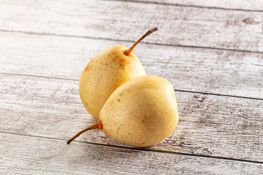 Two fresh Nashi pears on rustic wooden background
