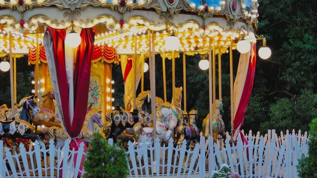 Enchanting evening view of a retro children&rsquo;s carousel with illuminated horses.
