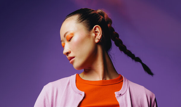 Asian woman with bold makeup in serene studio portrait