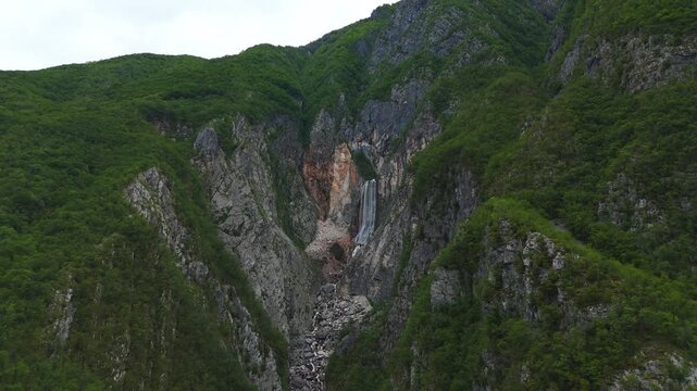 Breathtaking aerial drone view of majestic Boka waterfall flowing down steep rocky mountain slopes in Slovenia alpine landscape.
