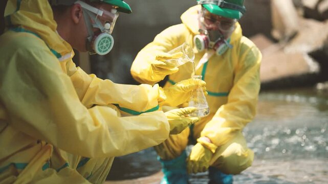 Two male technicians examining cloudy wastewater after sample collection, water turbidity testing, contamination inspection, pollution control, environmental monitoring, water analysis.
