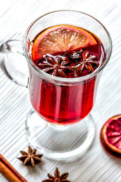 mulled wine with spices in cup on wooden background