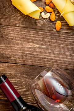 red wine with cheese on wooden background top view