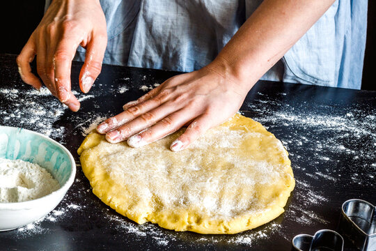 cooking homemade cookies with hands on dark background