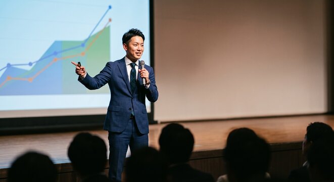 ビジネスコンテストのステージで新規事業アイデアをプレゼンする若手後継者