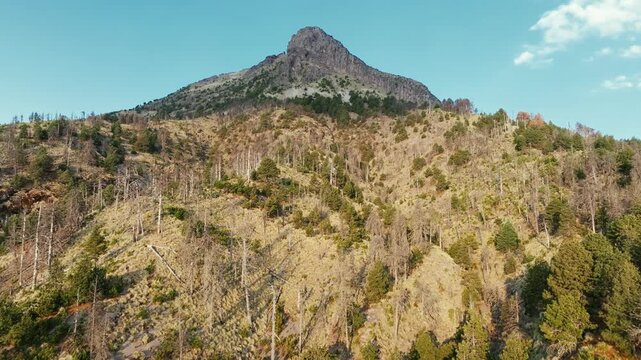 Nevado de Colima (Zapotepetl) peak rising above rugged forested slopes in Nevado de Colima National Park, Jalisco, Mexico. Establishing aerial shot.